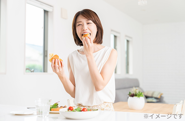 朝食にパンを食べる女性