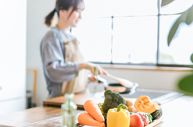 野菜とキッチンで料理する女性