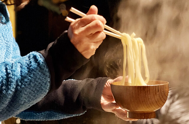 熱々のうどんを箸で持ち上げる
