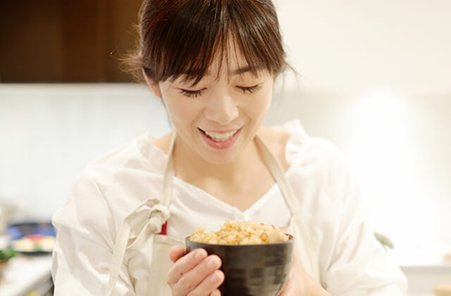 ほかほかの炊き込みご飯を持つ女性