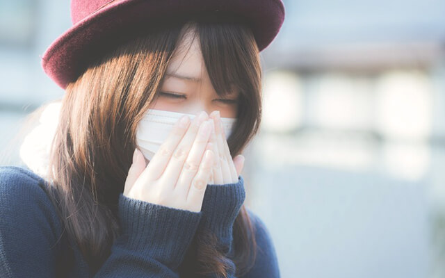 くしゃみをする花粉症の女性