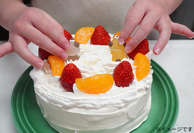 ケーキをデコレーションする子ども