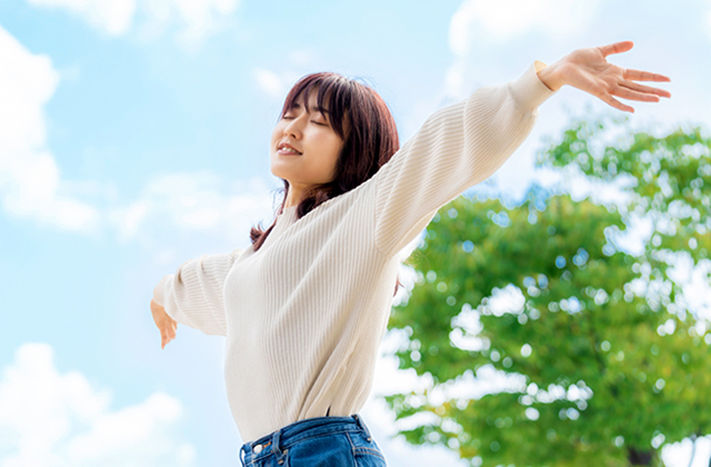 清々しく深呼吸をする女性