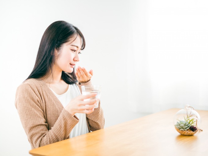 薬を飲む女性