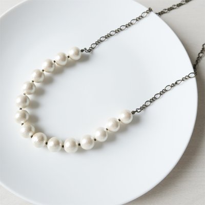 ボリュームあるコットンパールにブラックのデザインチェーンをセットしたネックレスの画像